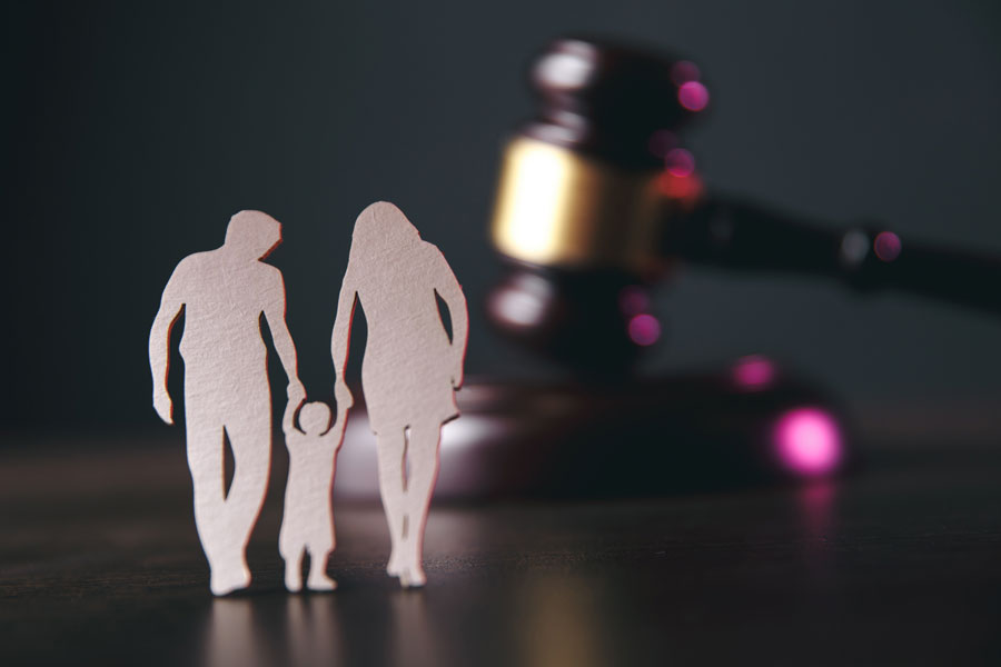 Sagome di una famiglia e martelletto del giudice